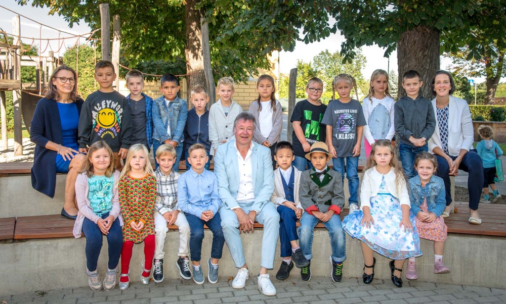 18 Kinder der 1a (mit Direktorin Gabriele Weiler (links) und Bgm. Ing. Martin Falk sowie Klassenlehrerin Isabella
                                    Stocklasser) sind am 4. September in ihr erstes Schuljahr gestartet. 